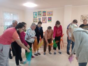 grupa miezkańców podczas zajęć muzycznych i ruchowych