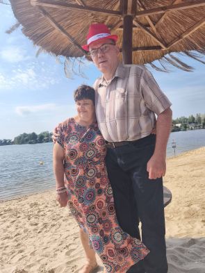 dwoje mieszkańców na plaży pod parasolem 