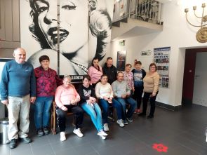 podopieczni z opiekunką w holu kina 