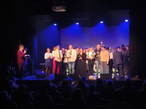 grupa uczestników WTZ z terapeutami na scenie