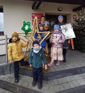 przedszkolaki z nauczycielami pozują do zdjęcia przed portiernią