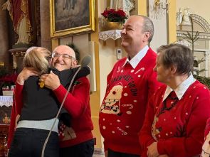 troje mieszkańców wraz z terapeutką która dziękuje uściskiem  jednemu z mieszkańców za udany występ